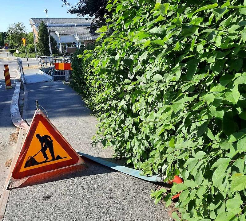 Slang och vägskyltar placerade på väg i Gråbo inför spolning av vattenledningar