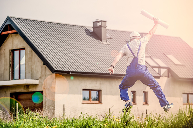Person i arbetskläder som hoppar framför ett hus. Foto: Pixabay