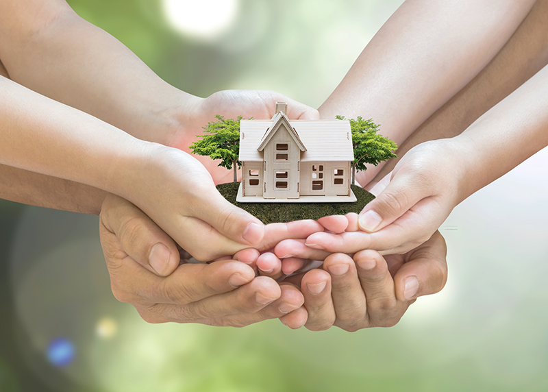 Händer som håller ett litet, litet hus. Foto: Shutterstock