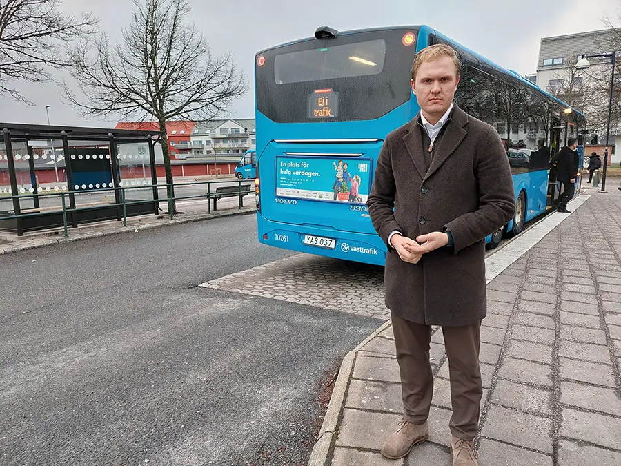 Kommunstyrelsens ordförande Viktor Lundblad vid en buss på Gråbo busstation.