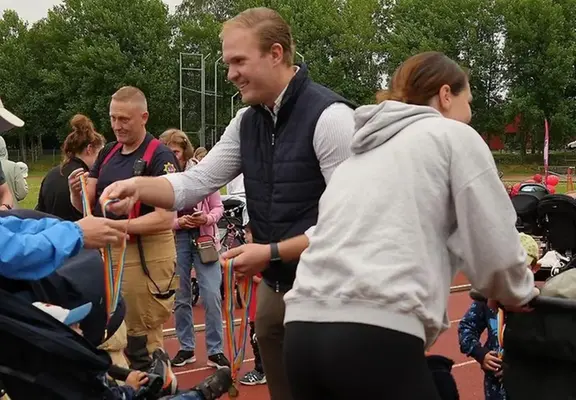 Politiker Viktor Lundblad ger en deltagare en medalj vid målgång. 